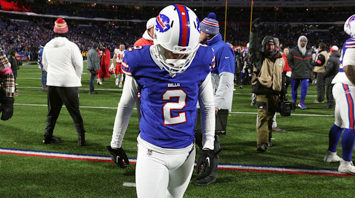 Tyler Bass hangs his head walking off the field